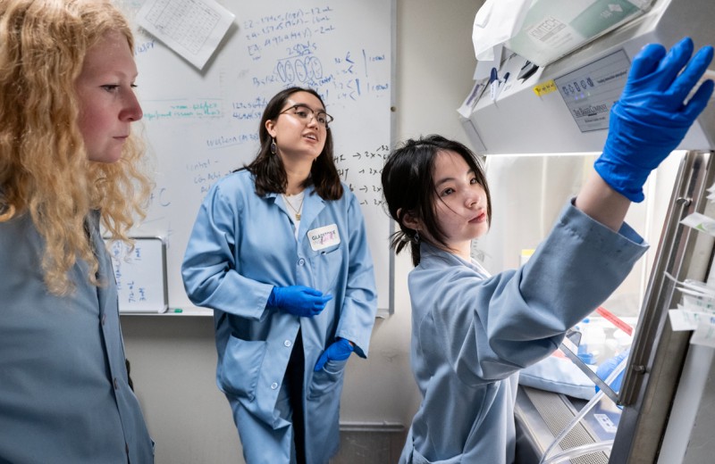 Gladstone postdoc and research associate working with a PUMAS intern in the lab